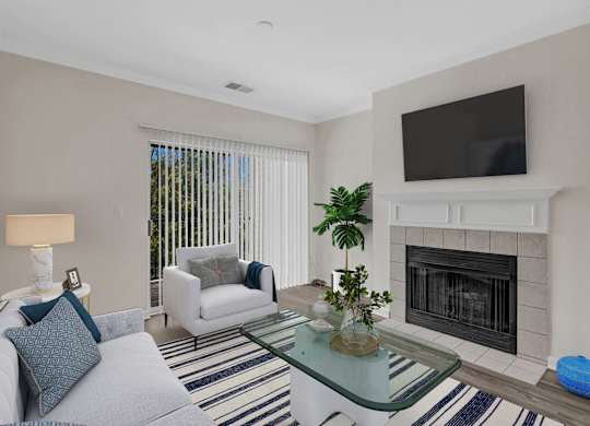 A living room with a fireplace and a television mounted above it.
