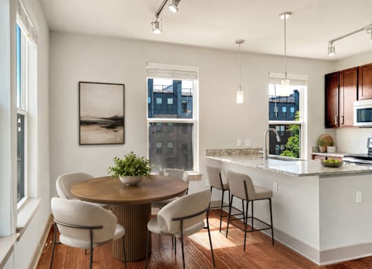 A modern kitchen with a dining table and chairs.