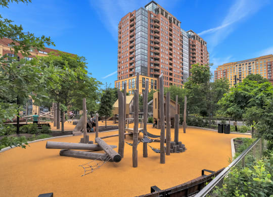 a playground at a park with tall buildings