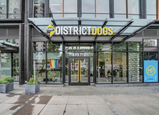 the front of a building with a sign that reads district dogs