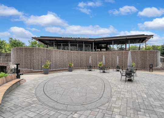 a circular patio with tables and chairs in front of a building