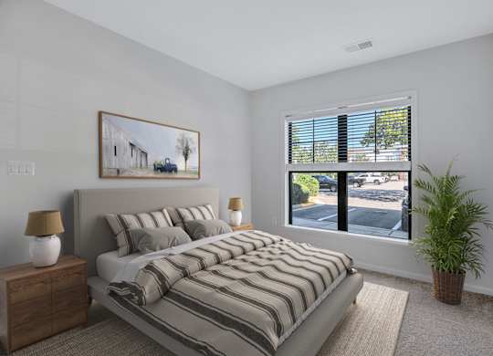 A bedroom with a large bed and a painting on the wall.