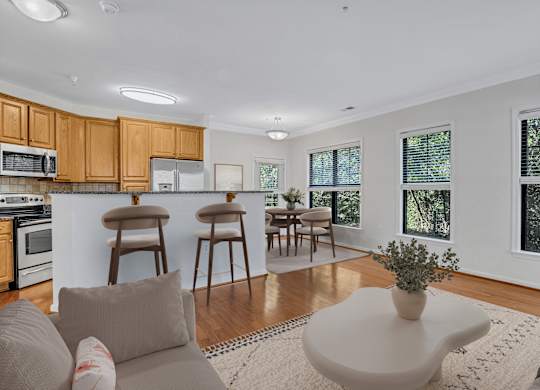 A modern kitchen with wooden cabinets and a dining area with a table and chairs.