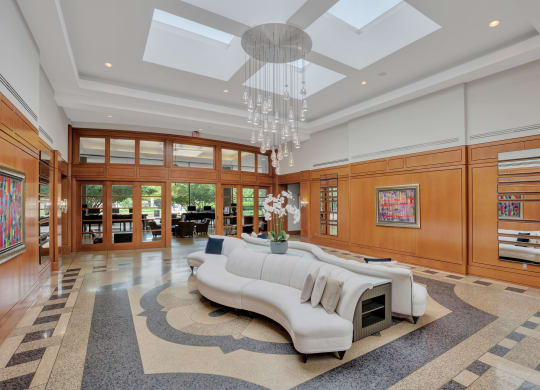 a large living room with a white couch and a chandelier
