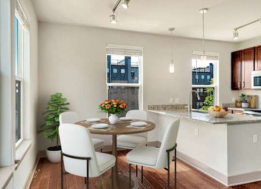 A kitchen with a table and chairs by a window.
