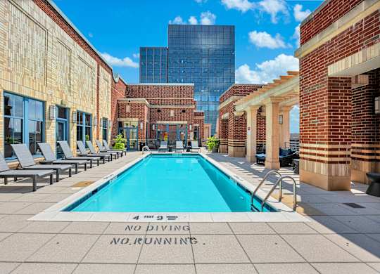 A pool surrounded by brick buildings with a sign that says