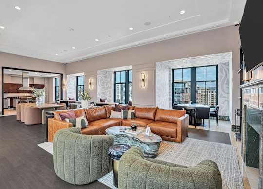 A spacious living room with a variety of seating options and a view of the city.