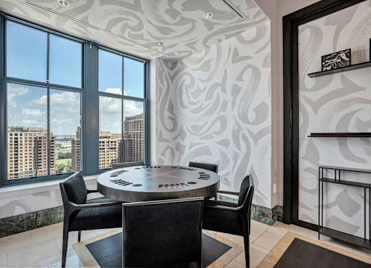 A dining room with a table and chairs and a view of the city.