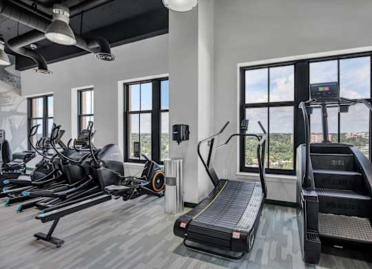 A gym with treadmills, exercise bikes, and elliptical machines.