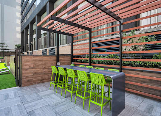 A patio with a table and chairs under a pergola.
