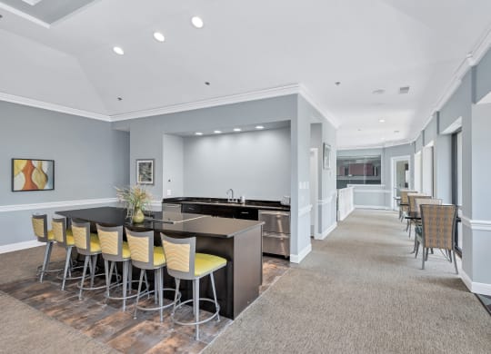a common area with a bar and chairs at the enclave at woodbridge apartments in sugar land