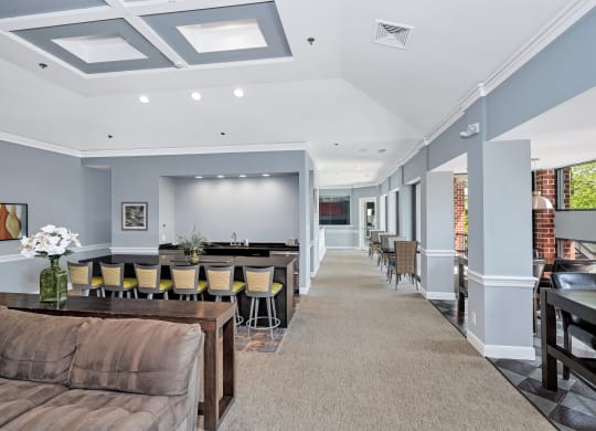 a room with a couch and chairs and a projector screen on the wall