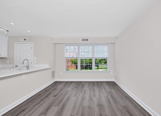 a bedroom with hardwood floors and a large window