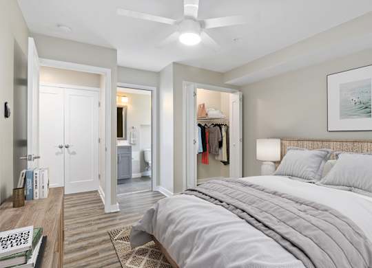 A bedroom with a large bed and a ceiling fan.