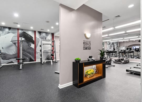 A gym with a variety of equipment and a sign that reads