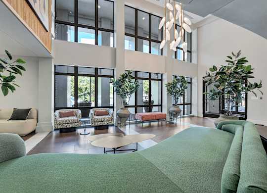 A large, modern living room with a green carpet and a chandelier.
