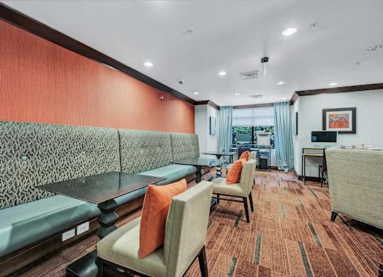 A room with a grey couch and a brown carpet.