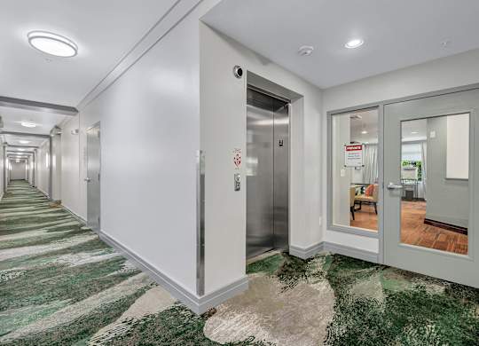 A long hallway with a green and white carpet.