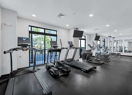 A spacious gym with treadmills, elliptical machines, and other exercise equipment.