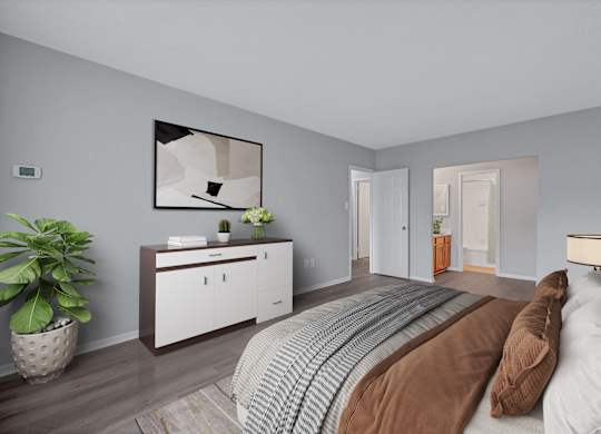 A bedroom with a bed, nightstand, and a plant.