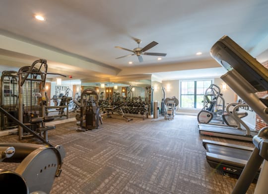 a large fitness room with exercise equipment and a large window