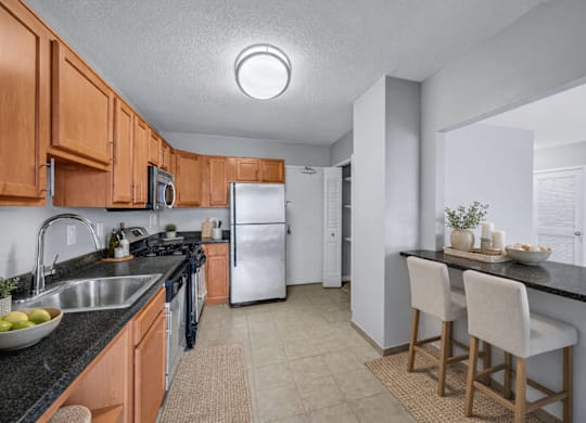A kitchen with wooden cabinets and a black countertop.