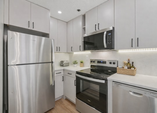 A modern kitchen with stainless steel appliances and white cabinets.