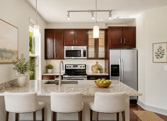 A kitchen with a granite countertop and white chairs.