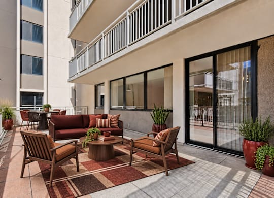 A patio with a table and chairs is surrounded by a white railing.