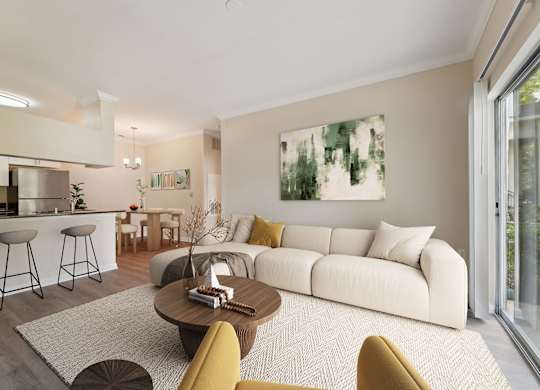 A modern living room with a white sofa, a coffee table, and a painting on the wall.