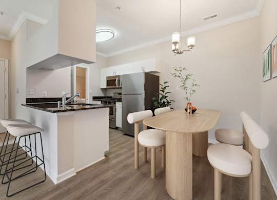 A kitchen with a table and chairs in the middle of the room.