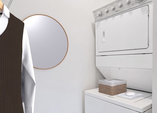 a white washer and dryer in a laundry room with a round mirror on the wall