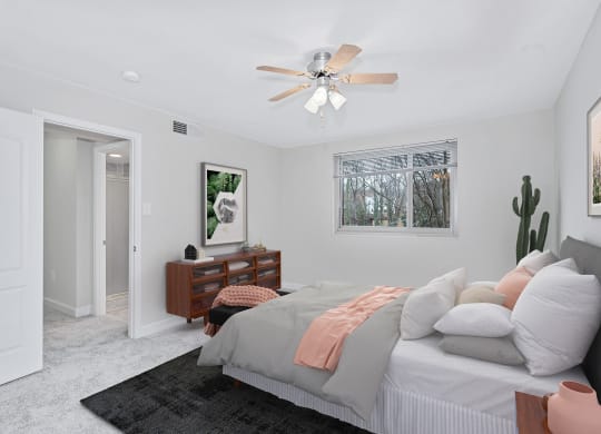 a bedroom with white walls and a white ceiling fan