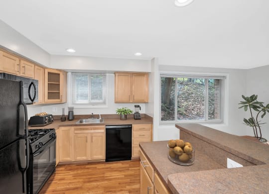 a kitchen with wooden cabinets and black appliances