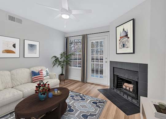 A living room with a fireplace, a couch, a coffee table, and pictures on the wall.