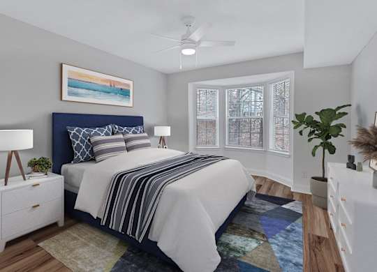 A bedroom with a bed, nightstand, and a painting on the wall.