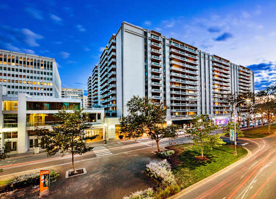A modern building with a parking lot in front of it.