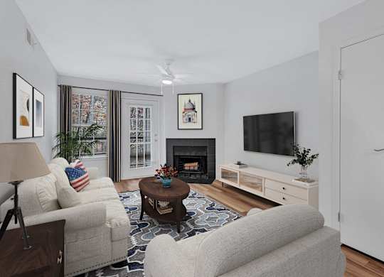 A living room with a fireplace, a couch, a chair, a coffee table, and a television.
