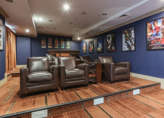 a cinema room with blue walls and brown leather chairs