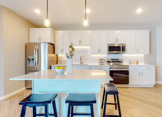 A kitchen with a white counter and blue stools.