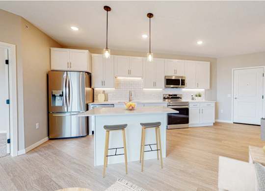 A modern kitchen with a bar area and a dining area.