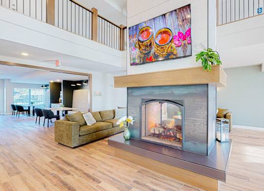 A living room with a fireplace and a painting above it.