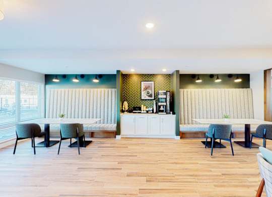 A room with a white counter and blue chairs.