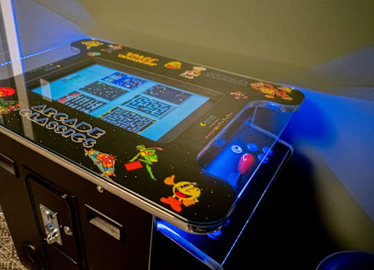 A pinball machine with a black background and colorful designs.