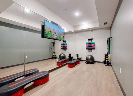 A room with a bowling alley and a television mounted on the wall.