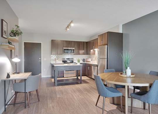 A modern kitchen with a dining table and chairs.
