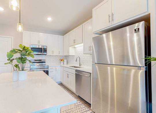 A modern kitchen with a large island and stainless steel appliances.