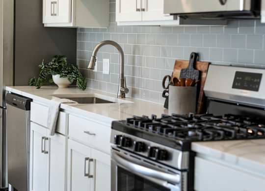 a kitchen with white cabinets and stainless steel appliances