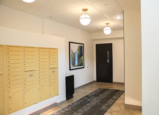 a view of the hallway with lockers and a painting on the wall