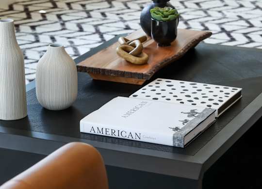 a black coffee table with a black and white geometric rug on top